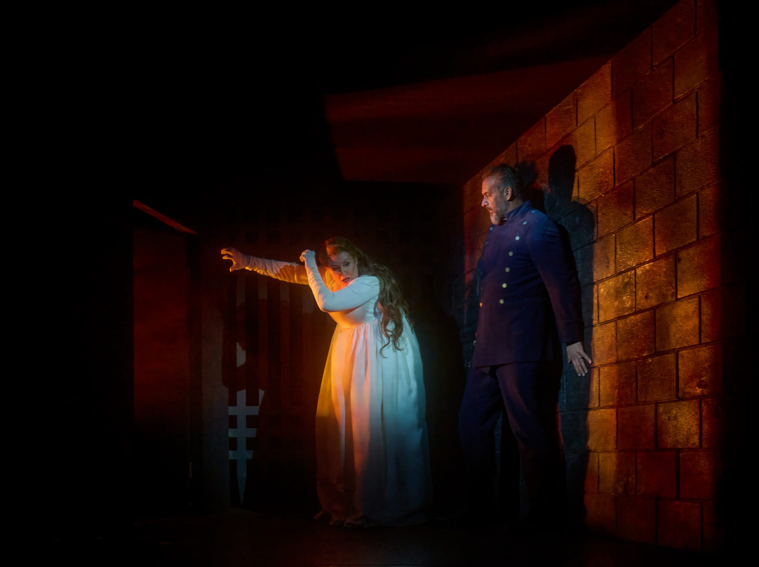 Judith blinded by the light from one of the doors, Bluebeard behind her