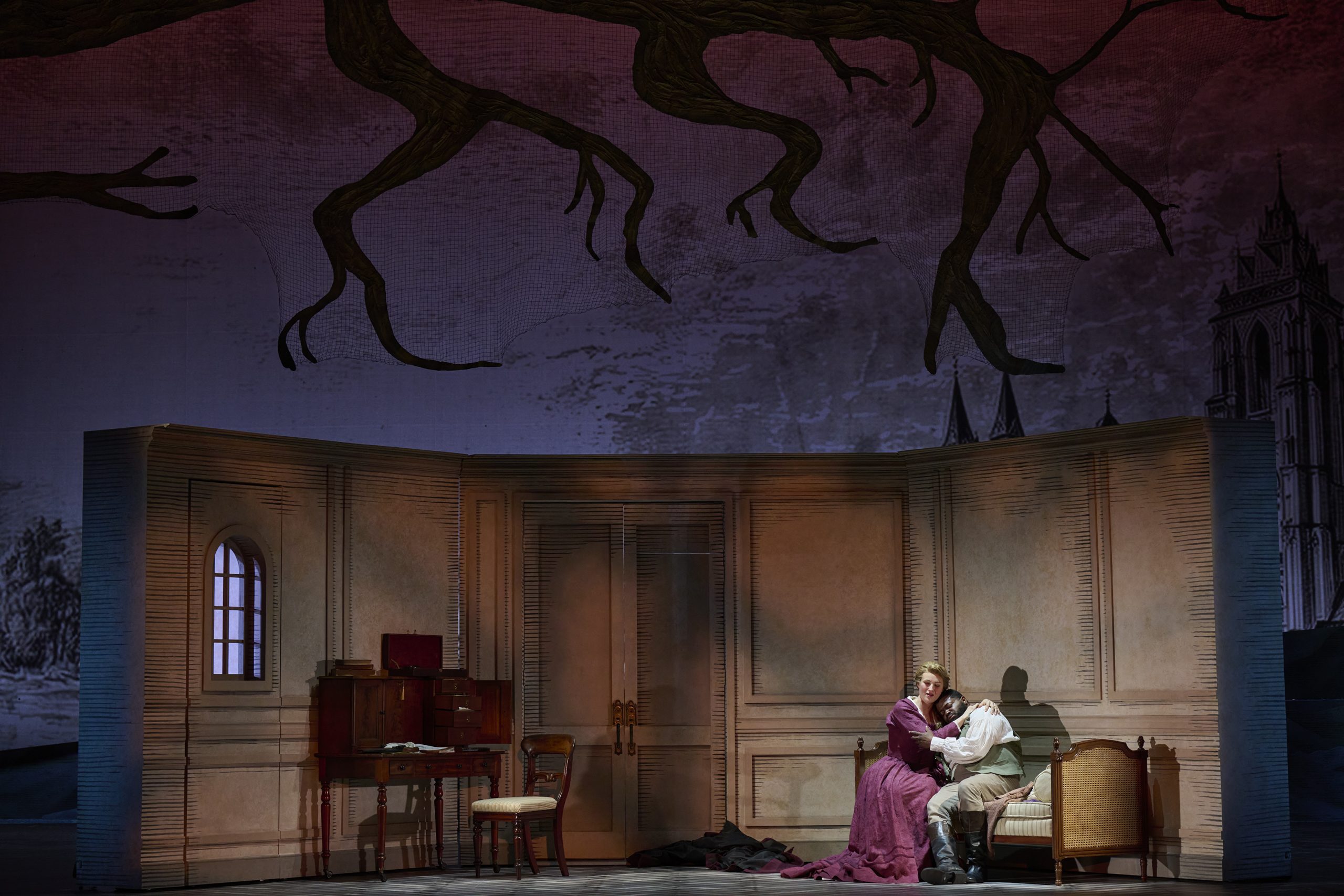 A long distance shot of the scene of Werther's room, the branch overhead, Werther in Charlotte's arms.