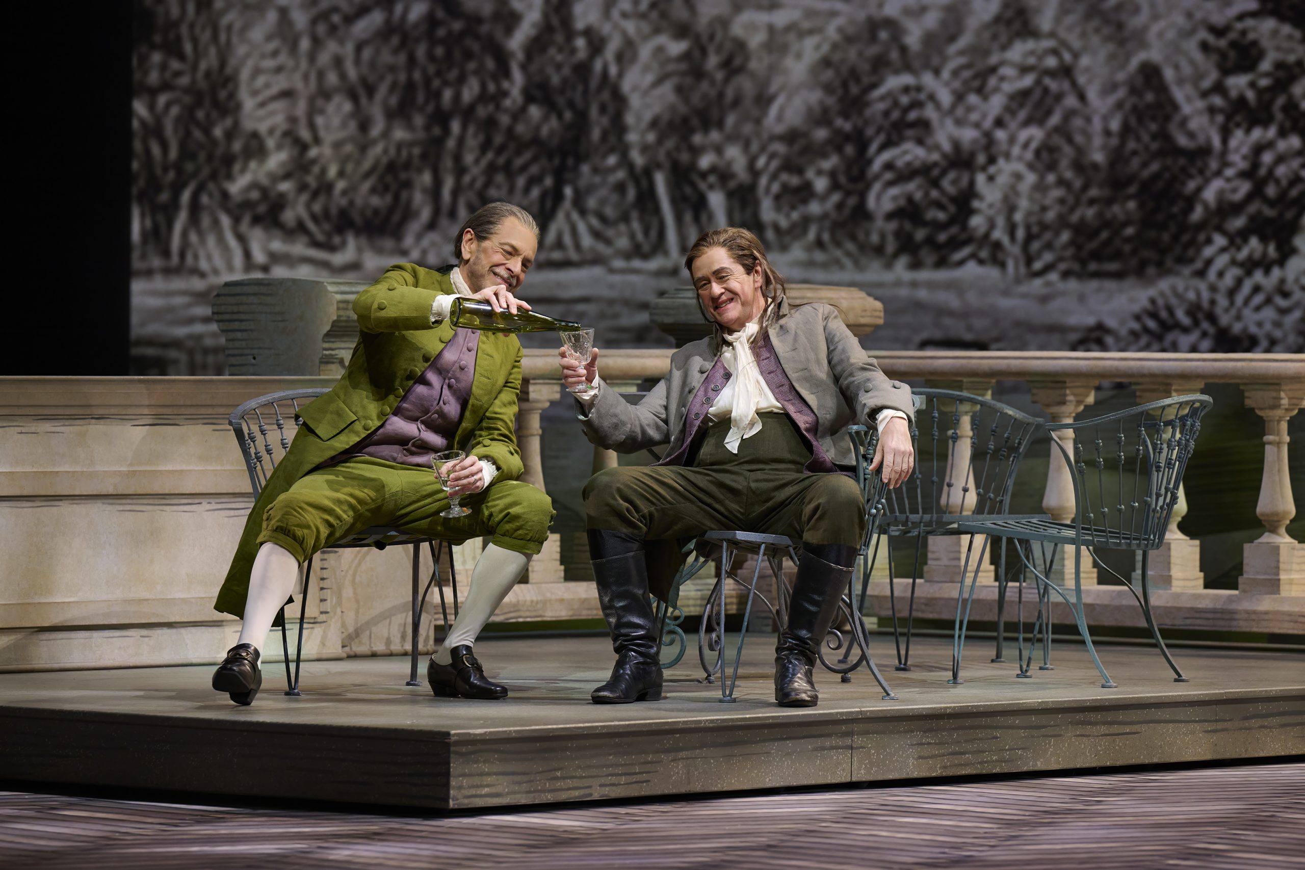 Johann pouring a drink for Schmidt on the Bailiff's terrace and both are laughing